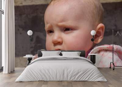 Little adorable blonde baby girl stands and holding favorite spoon,looking at the somewhere also this cute baby serious and her hand dirty Wall mural