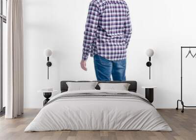 A man in jeans and shirt looks up on a white background. Isolation, back view Wall mural