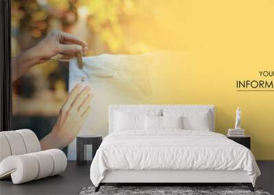 White jeans hanging on a clothespin female hand nature pattern on blur background Wall mural