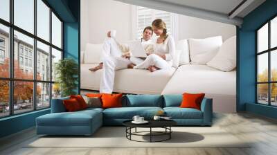 Father and teen daughter on white living room sofa using laptop Wall mural