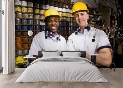 male coworkers by shelves of colored inks in print shop Wall mural