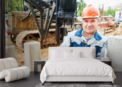 construction worker in front of pile driver machine Wall mural