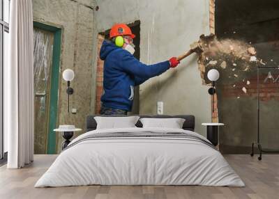 demolition work and rearrangement. worker with sledgehammer destroying wall Wall mural