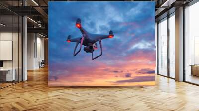 drone quadcopter with digital camera flying at sunset Wall mural