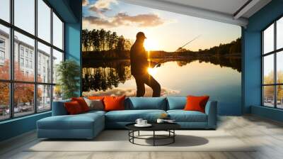 sunset fishing. fisher with spinning rod Wall mural