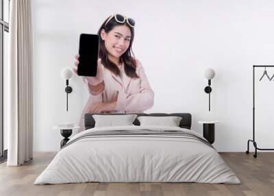 Cheerful positive asian woman sunglasses showing mobile phone empty screen standing on isolated white background. Businesswomen wear suit holding smartphone looking camera. Technology app on cellphone Wall mural