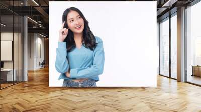 Positive Asian woman think choice creative on white background. Smile girl thinking about question, pensive expression something over isolated. Lady thoughtful doubt holding finger on head looking up. Wall mural