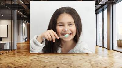 Happy cute little child girl brushing her teeth on white background. Space for text. Healthy teeth.  Wall mural