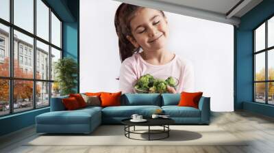 Happy smiling child girl eating vegetables. Healthy food. Fresh broccoli. Wall mural