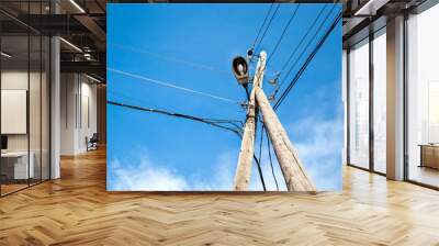 Old  wooden street lantern with cables on blue sky background. Wall mural