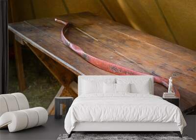 traditional and medieval wooden bow, old and weathered, small arms lying on the table Wall mural