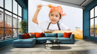 Close up shot of Asian little girl hold the honey dipper with ha Wall mural