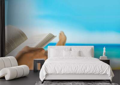 blurred reading book and relax on beach table with sea view Wall mural