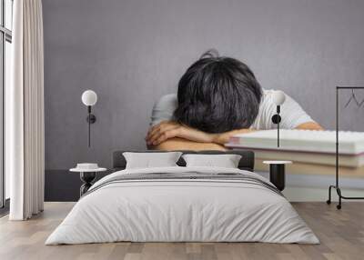 Man face down the table with books Wall mural