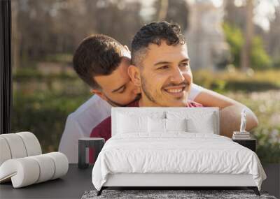 gay couple in the park, cuddling, loving and playful Wall mural