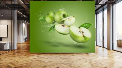 Water Splashing on Green apple and cut slice with seed on green background. Wall mural