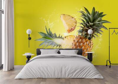 Water Splashing on Split Pineapple Fruit isolated on a yellow background. Wall mural