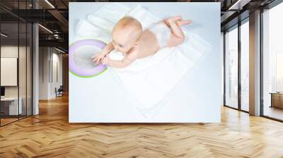 a baby with a mirror lies on a white background. banner with a copy space.  Wall mural