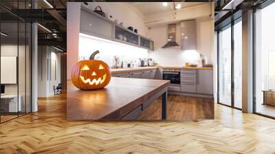 A glowing orange jack-o-lantern sits on a wooden kitchen counter, a spooky Halloween decoration. 
 Wall mural