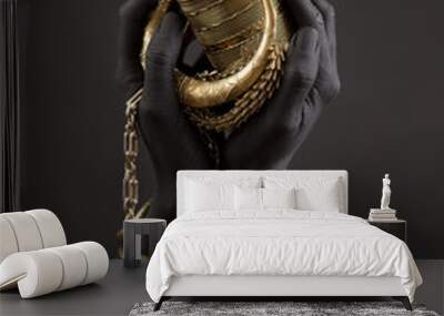 Black woman's hands with gold jewelry. Oriental Bracelets on a black painted hand. Gold Jewelry Wall mural