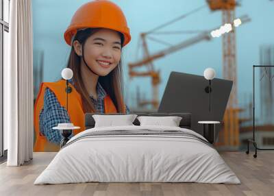 Skilled hispanic woman engineer in safety vest and hard hat working on laptop at modern construction site office
 Wall mural