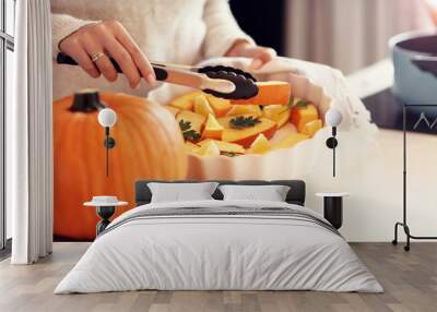 Adult woman in the kitchen preparing pumpkin dishes for Halloween Wall mural