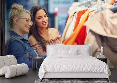 Girl friends shopping for clothes in store Wall mural