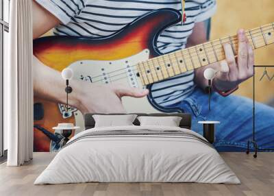 Handsome man playing guitar in studio Wall mural