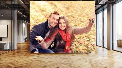 Happy couple relaxing in the autumn park Wall mural