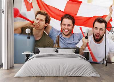 Happy male friends cheering and watching sports on tv Wall mural