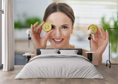 Healthy adult woman with green food in the kitchen Wall mural