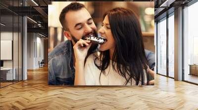 Romantic couple dating in cafe and eating donut Wall mural