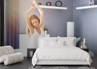 Young beautiful woman waking up in her bed fully rested Wall mural