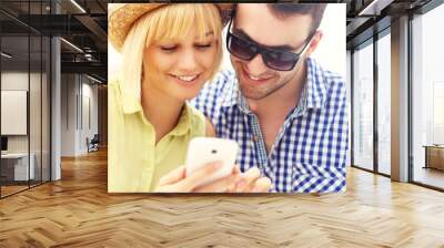 young couple using a cellphone Wall mural