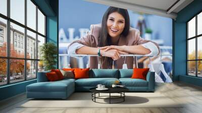 Young woman as a store manager with clothes Wall mural