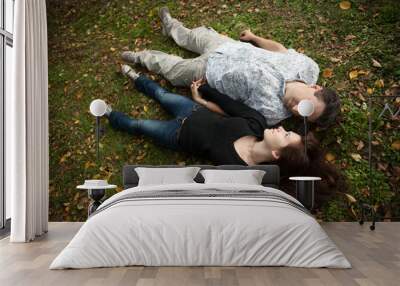 Loving couple lying on the grass Wall mural