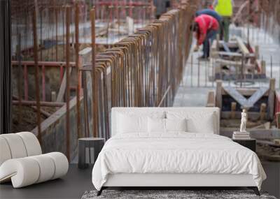 blurred workers and steel reinforcement in foundation of new bu Wall mural