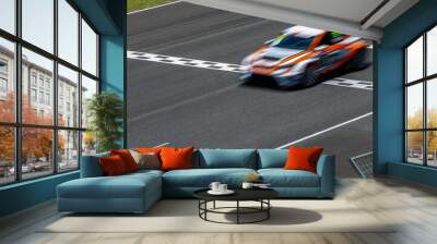 Motion blur race car racing on speed track, Car race on the international circuit race track crossing start and finish line, Race car crossing start and finish line, Target business achieve victory. Wall mural