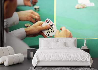 Gambling in cards. Cards in the hands of the player on a green background Wall mural