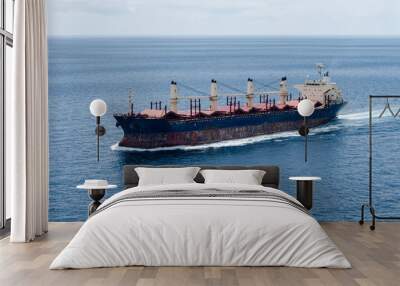 A old bulk carrier or bulker sails in the sea to trade around the world Wall mural