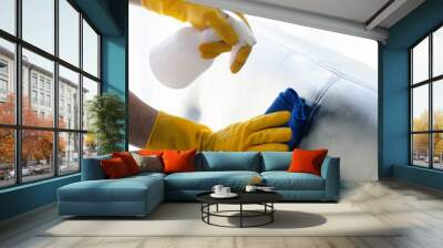 Person cleaning the room, cleaning staff is using cloth and spraying disinfectant to wipe the sofas in the company office room. Cleaning staff. Maintaining cleanliness in the organization. Wall mural