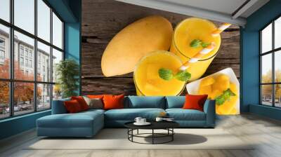 Mango smoothies orange colorful fruit juice beverage healthy high protein the taste yummy in glass on wood background from top view.
 Wall mural