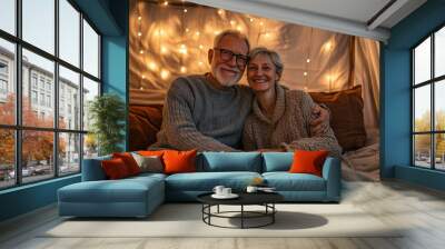 A joyful older couple embracing together, surrounded by warm lights, exuding love and comfort in a cozy indoor setting. Wall mural