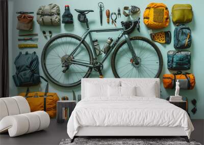 Against a serene light blue backdrop, the essentials of a bikepacking adventure are meticulously laid out in a knolling arrangement Wall mural