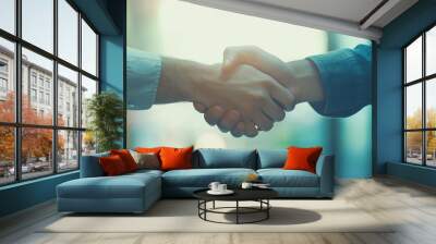 Close-up of two business professionals shaking hands, symbolizing agreement and partnership in a bright, modern office environment. Wall mural