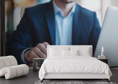 Professional man working on a laptop in a modern office environment. Wall mural