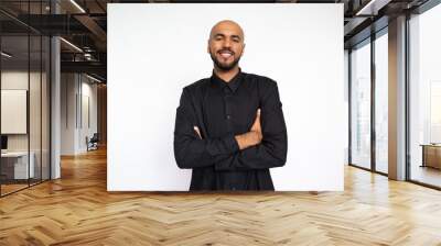 Portrait of confident young man crossing arms. Proud Latin American male model with bald head and beard in black shirt looking at camera with crossed arms. Self-assurance concept Wall mural