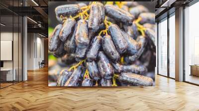 Extra jumbo size of black seedless Moon Drops grape or Witch Fingers grape for sale at the fruit market. Organic sweet long black sapphire grapes on sale. Wall mural