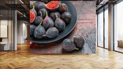 side view of full fresh black mission figs split ones on a black plate on red stripped towel on colo Wall mural