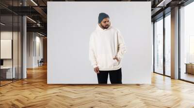 African American man in a knitted hat and white oversized hoodie. Wall mural